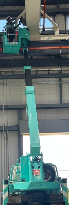 高所作業車を利用してクレーンのメンテナンス作業をする様子。