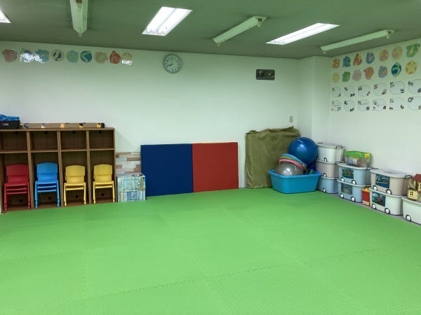 広い教室で、子どもたちは元気に遊んだりリラックスしたりしています。