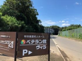 こちらの看板が目印です。奥の３階建ての建物です。