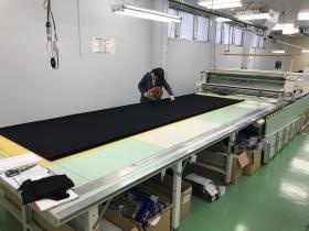 裁断作業、生地を用尺に合わせて重ねていきます