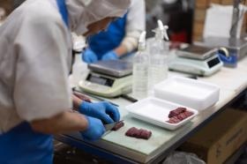 生産現場にて。お肉を包丁で切り分けています