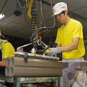 成形工程。製品を機械で持ち上げ、台車に積んでいます。