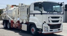 ホースを使って泥や粉を吸い取る清掃作業用の車両写真