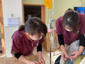 先輩ナースの指導のもと処置を行っています。