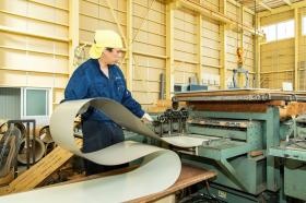 製造：鋼板をロール成型機に投入し、屋根材を製造しています