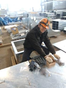 製品出荷前に、ボルト付作業中の井上主任