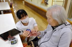 仕事風景（ＩＣＴを活用してバイタルサイン測定）