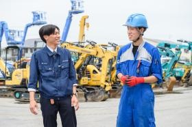 ヤードをバックに若手社員