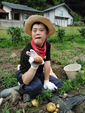 利用者の方と畑で野菜作り。ジャガイモでピース！
