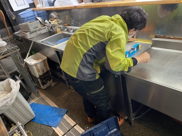 すでに営業している飲食店で厨房機器の入れ替えをしている様子です。お客様が安心して使えるようにきちんと設置出来ているかチェックをしています