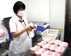 看護助手が入院患者さんの口腔ケア物品を綺麗にしています