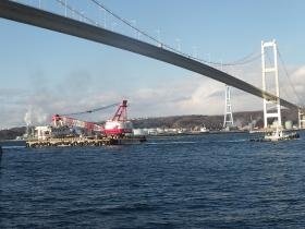 北興工業株式会社の所有作業船が白鳥大橋を背に現場へ向かう