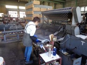金網機による金網の製造：金網を畳んでいます