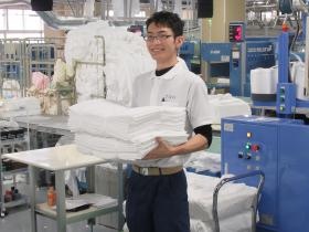 工場内でのシーツ類の梱包スタッフ