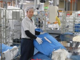 工場内でのシーツ類の仕分け投入スタッフ
