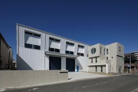 本社外観 左が工場 右の丸い窓が特徴的な事務所