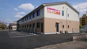 施設の外観。大通り沿いにあり、すぐ隣には公園も。