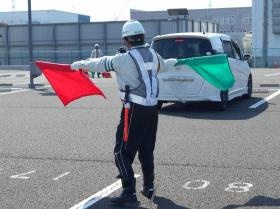 教育研修で車両の後進誘導を実技練習する警備員