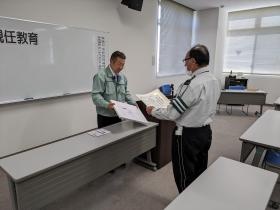 永年勤続表彰される警備員。賞状と商品券、祝金を受け取りました