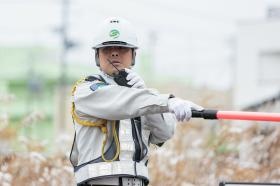 同僚からの無線で片交の最終車両を確認する警備員の様子