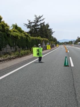東北自動車道上で減速旗を使った規制をしている警備員の様子。