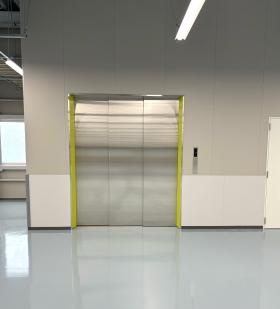 撮影した設置者の陰が映る、新設エレベーターのピカピカなドア