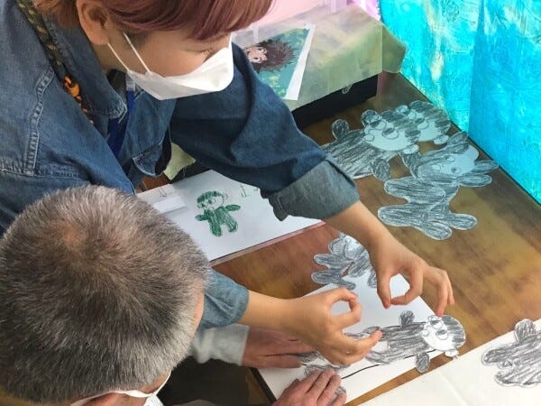 商品製作の一コマ。できあがったイラストの印刷位置を利用者さんと決めています。