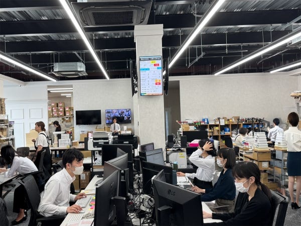 オフィス１階はDTP印刷加工部とプロダクションアッセンブリ部のフロア、20代～60代まで幅広い年齢がチームで協力して価値あるサービスを提供。