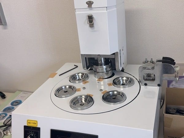 缶バッジを生産する機械で日産１００個半自動で作ってます。