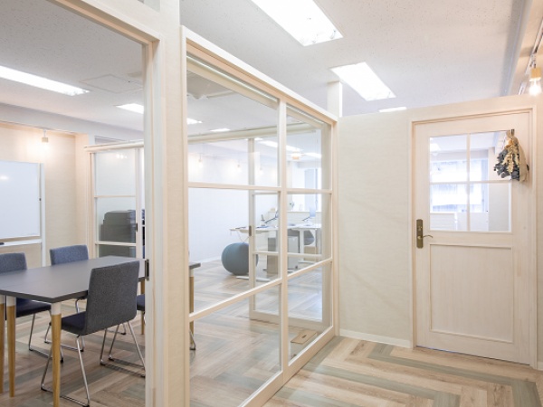 白を基調としたおしゃれな執務室、奥の窓側にはカフェカウンターがあり、カフェのような雰囲気です。