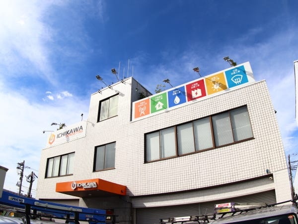 本社の外観です。駐車場も併設されております。弊社のイメージカラーであるオレンジが目印！