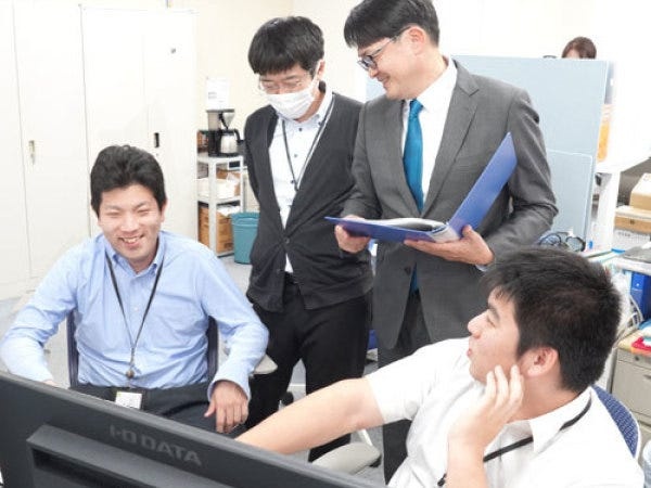 営業スタッフとエンジニアがデスク周りで打合せをする様子