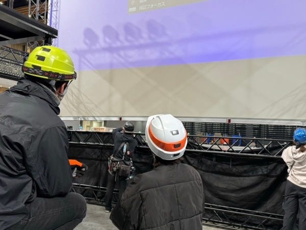 イベント現場での、スクリーンとプロジェクターの仮設風景です。