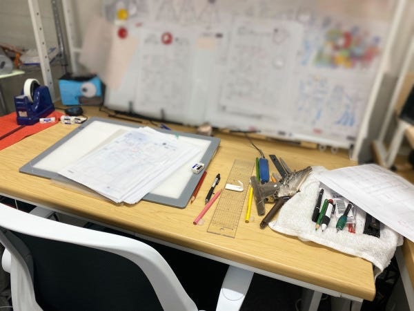 作画さんの机の様子です。設定資料などが沢山あります。