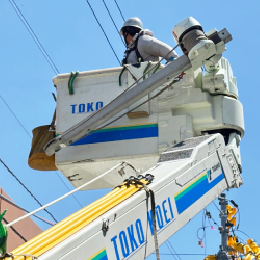 高所作業車で高さ10～15m付近まで上がり作業をします。直接電柱を昇り降りすることも。