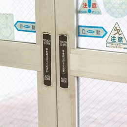 街でよく見かける青いステッカー。これが貼られている自動ドアが、ナブコ製品です。