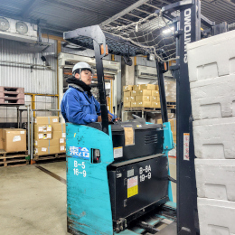検品作業とフォークリフトでの商品移動が主な業務。フォークリフト未経験の方でも免許取得を支援します。