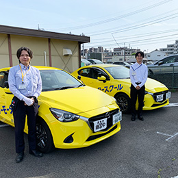 爽やかなイエローの教習車とともに。「一緒に楽しく働きましょう！」