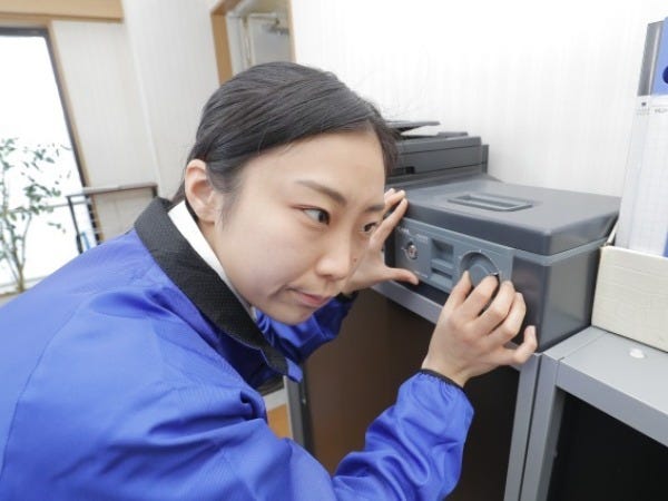 金庫の鍵開け作業中です。正しいダイヤル番号を手の感覚を頼りに探っています。